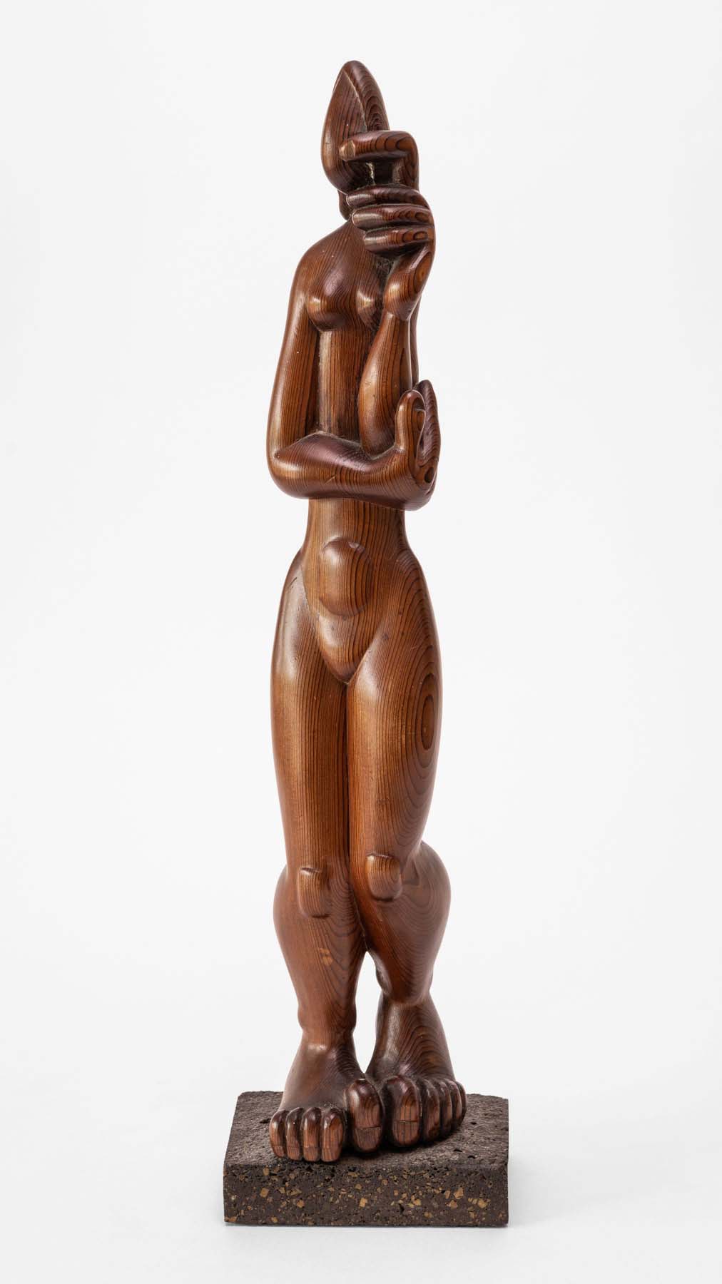 A carved wood sculpture of a bulbous, naked standing figure with very abstract features.