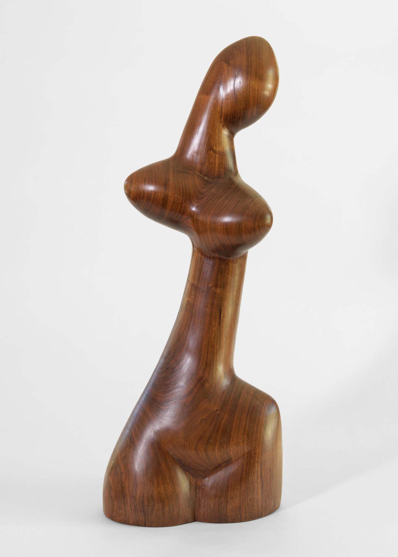 A carved wood sculpture of an slender, abstracted female head and torso.