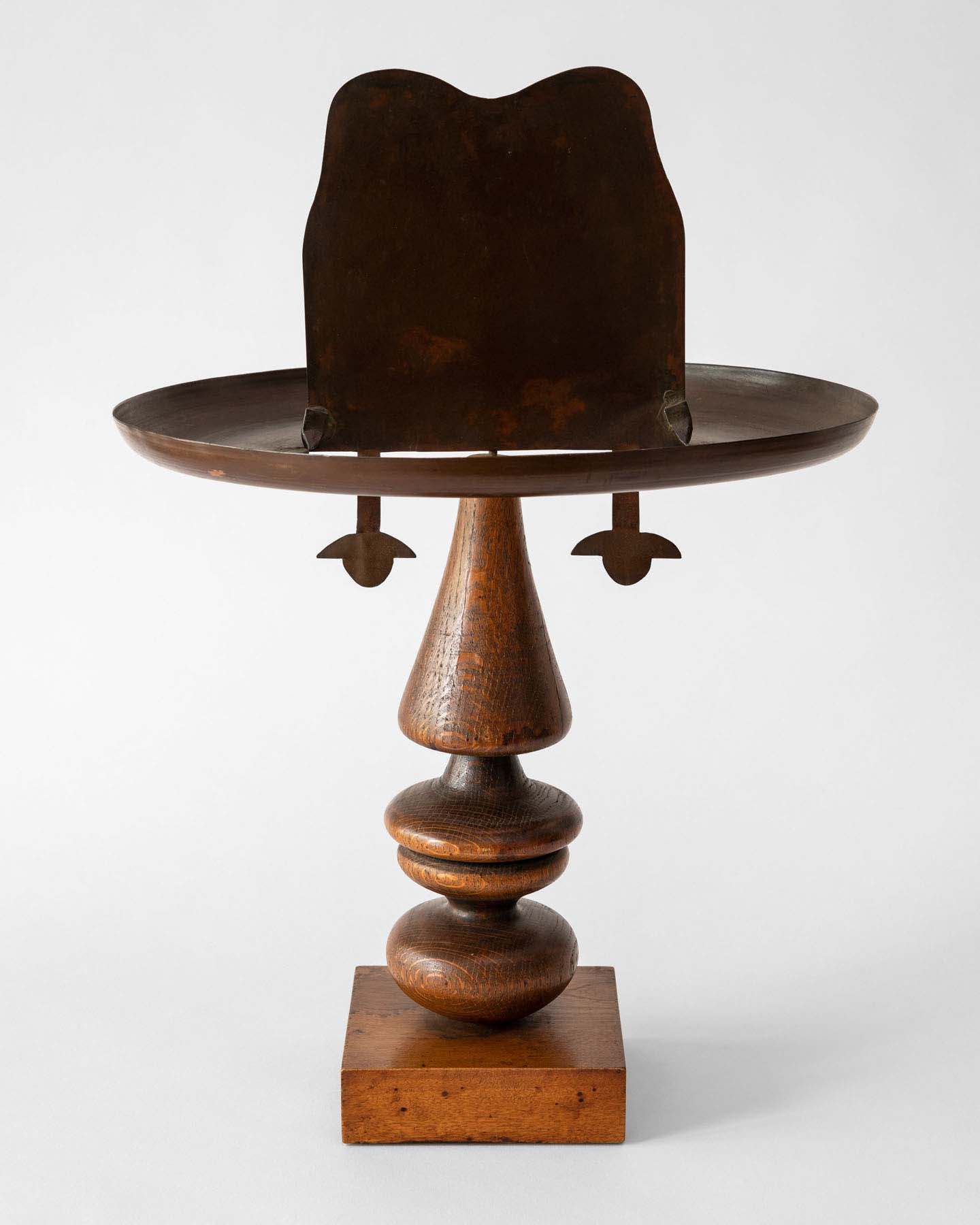 A wood and copper abstract sculpture of a cowboy head.