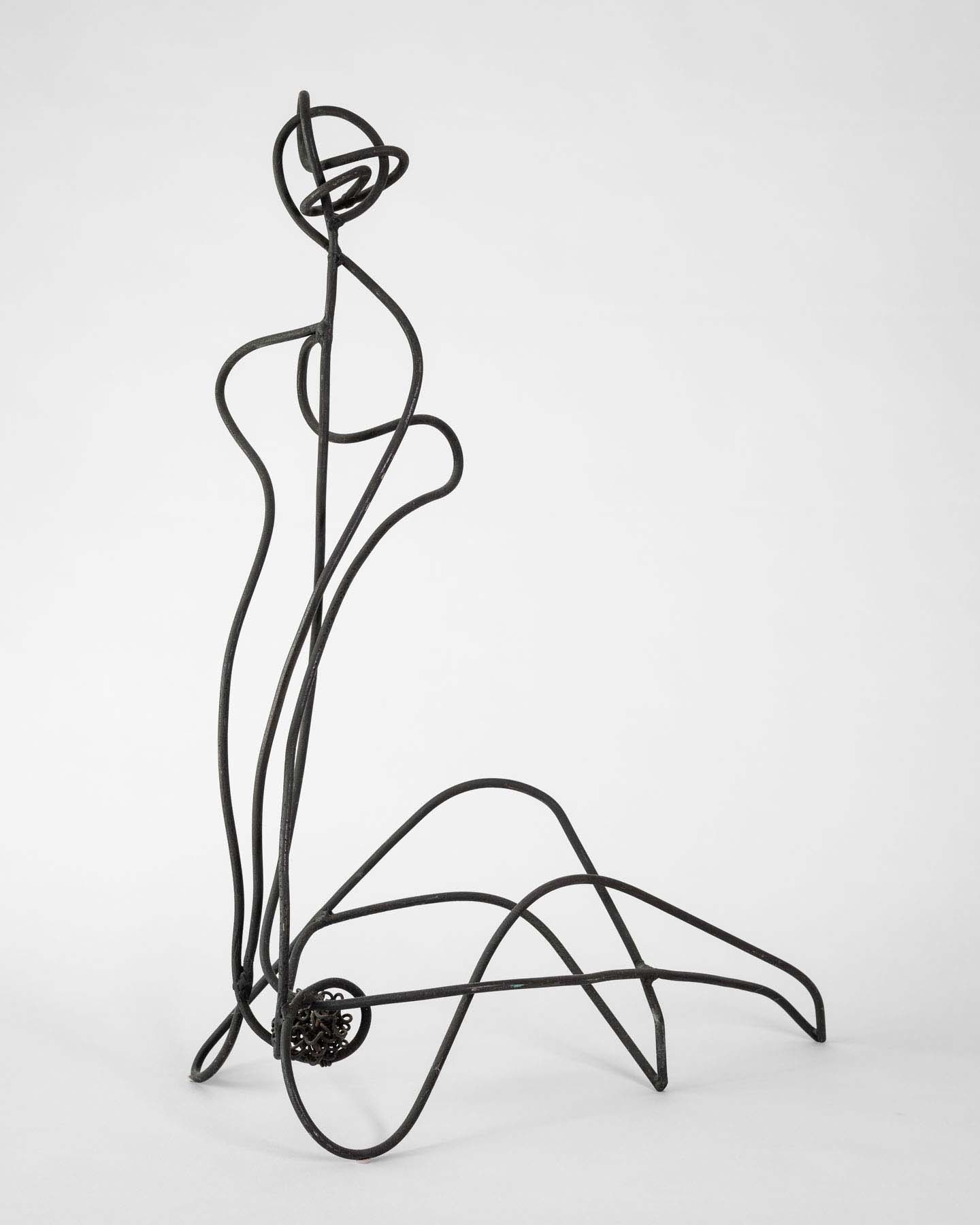 An abstract wire sculpture of a seated figure.