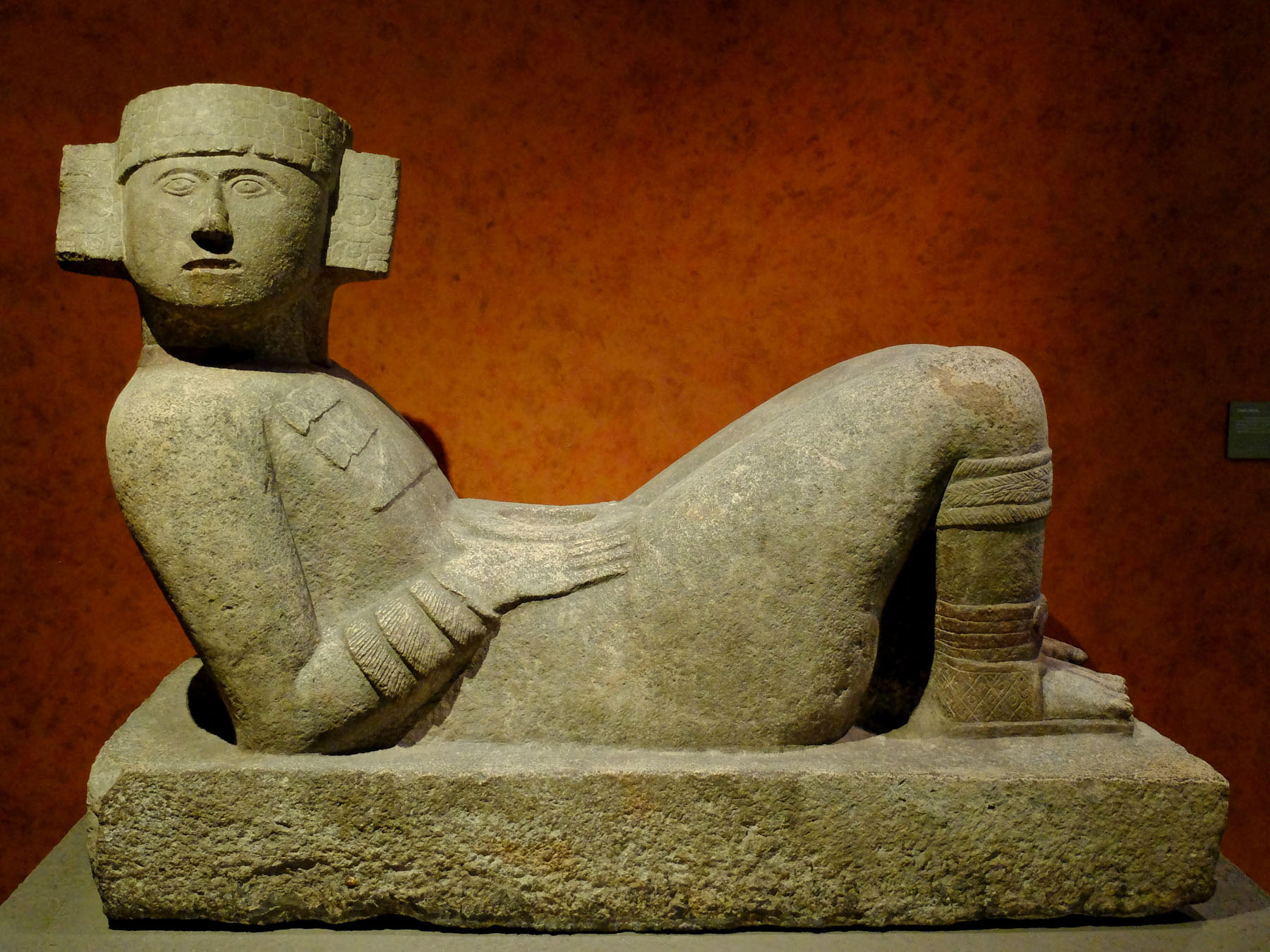 Stone sculpture of a reclining human figure.