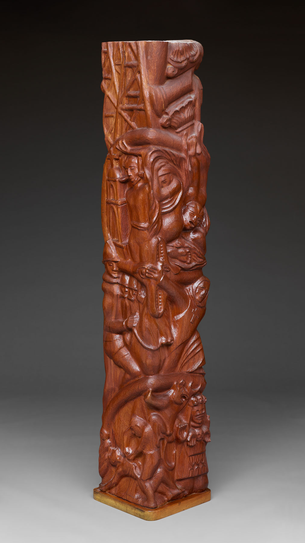 A wood totem-like sculpture featuring human and animal figures.
