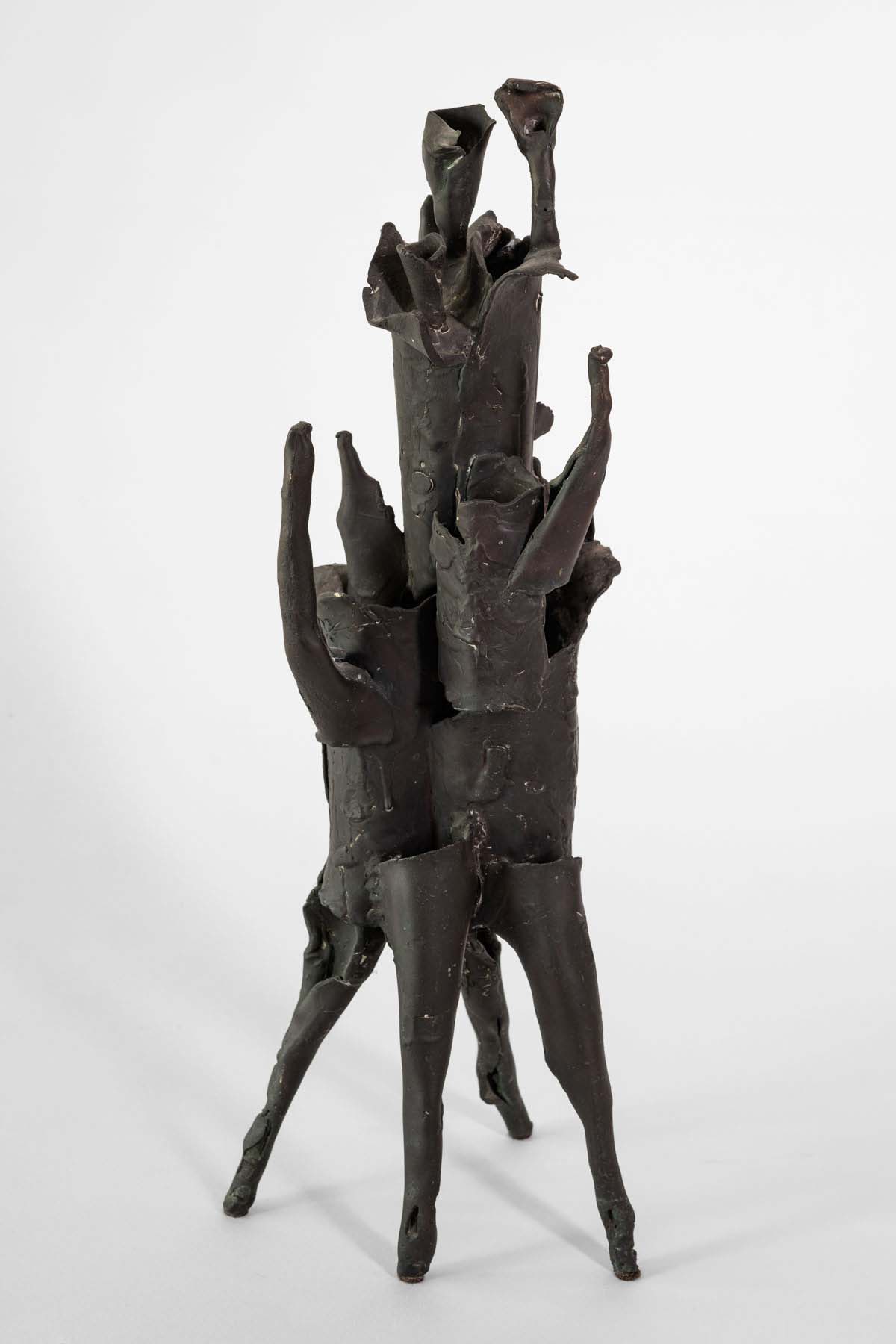 Bronze sculpture that stands on four legs and has several pointed edges as it tapers off at the top.