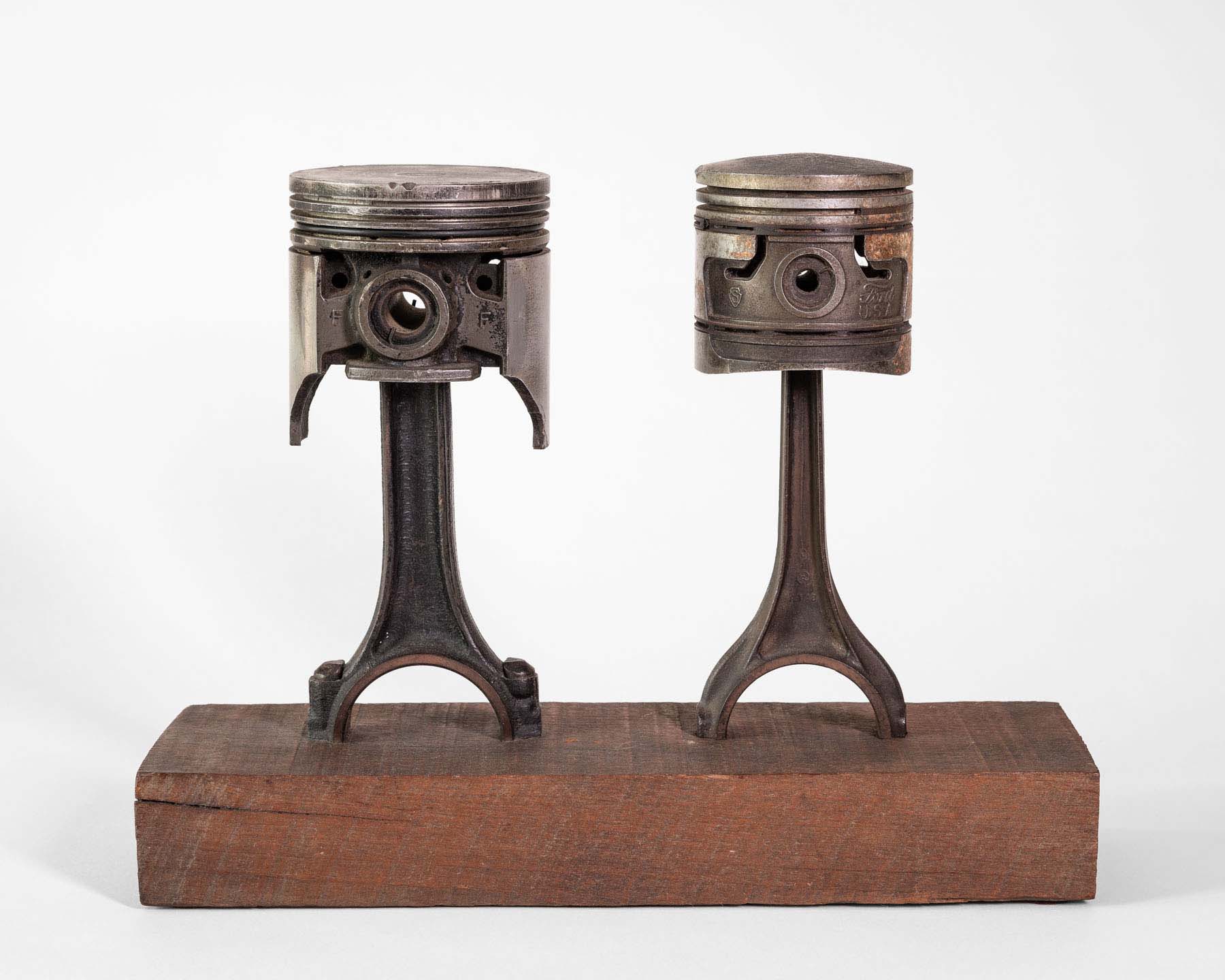 Two pieces of forked steel mounted on a wood block with a round metal piece on the top of each.